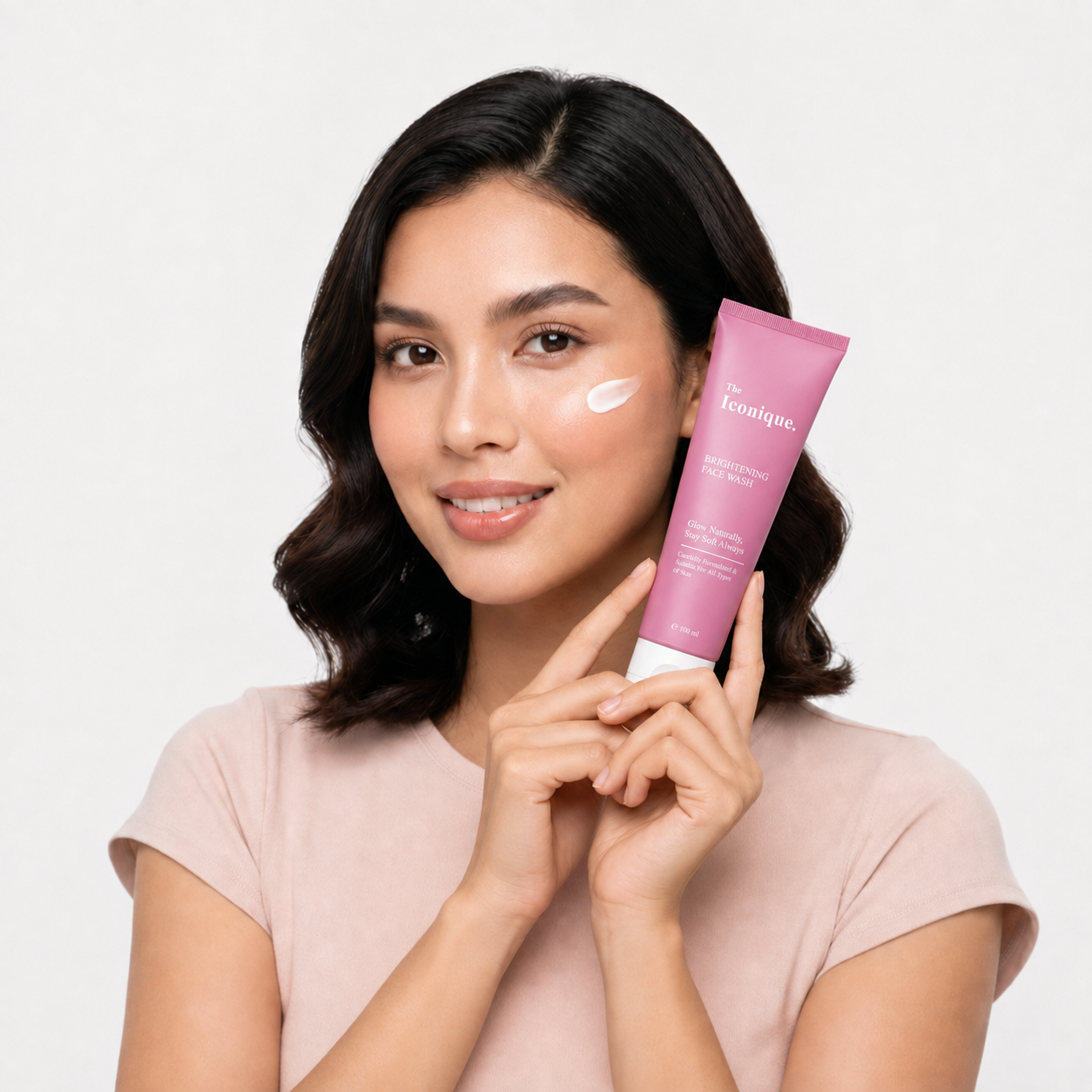 Smiling woman holding The Iconique Brightening Face Wash
